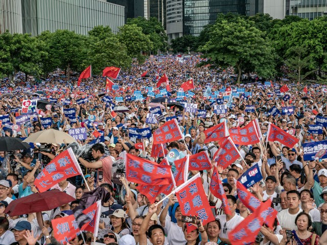 Demonstrators wave Chinese flags and shout slogan during a rally on June 30, 2019 in Hong
