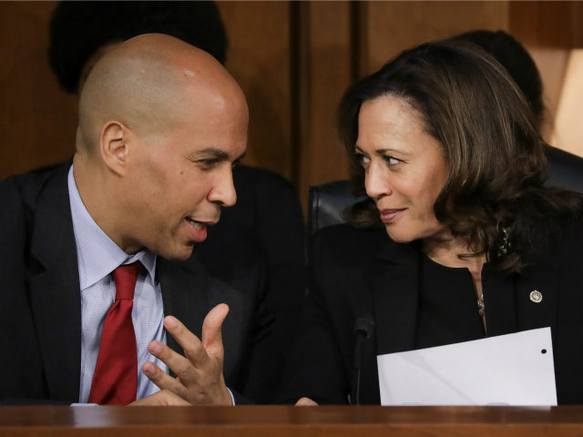 (L-R) Sen. Cory Booker (D-NJ) and Sen. Kamala Harris (D-CA) talk with each other as they l