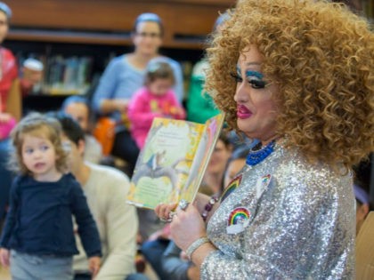 In this Saturday, May 13, 2017 photo, Lil Miss Hot Mess reads to children during the Femin