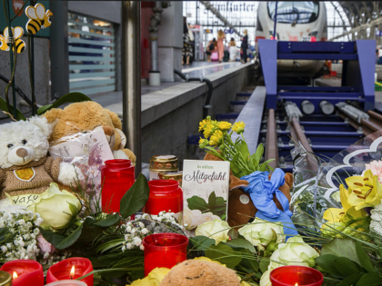 Flowers and candles lay near a track at the main train station in Frankfurt, Germany, Tuesday, July 30, 2019. An eight-year-old boy was pushed on the rails and died on Monday, July 29, 2019. (Frank Rumpenhorst/dpa via AP)