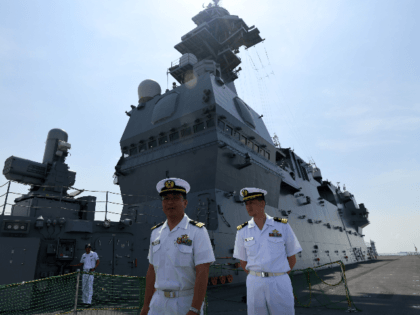 Japanese navy officers walk along the flight deck onboard the JS Izumo naval ship during a