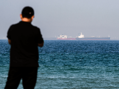 A man stands along a beach as tanker ships are seen in the waters of the Gulf of Oman off the coast of the eastern UAE emirate of Fujairah on June 15, 2019. (Photo by GIUSEPPE CACACE / AFP) (Photo credit should read GIUSEPPE CACACE/AFP/Getty Images)