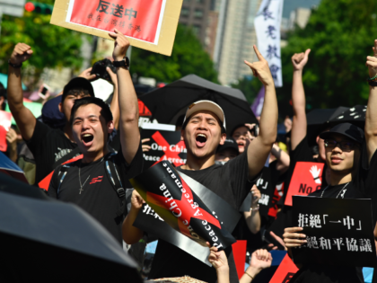 Protesters display placards during a demonstration in Taipei on June 16, 2019, in support of the continuing protests taking place in Hong Kong against a controversial extradition law proposal. - Tens of thousands of people rallied in central Hong Kong on Sunday as public anger seethed following unprecedented clashes between …