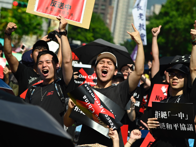 Protesters display placards during a demonstration in Taipei on June 16, 2019, in support