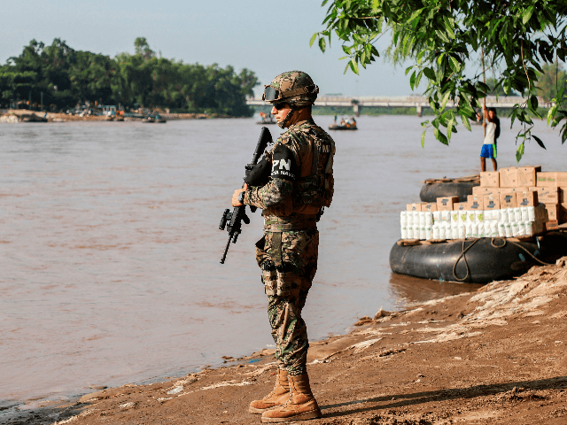 A naval police officer patrols the banks of the Suchiate river in Ciudad Hidalgo, Chiapas