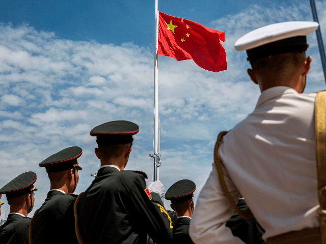 Soldiers of the Peoples' Liberation Army (PLA) during a flag raising ceremony at an open day at the Ngong Shuen Chau Barracks in Hong Kong on June 30, 2019, to mark the 22nd anniversary of Hong Kong's handover from Britain to China on July 1. (Photo by ISAAC LAWRENCE / …