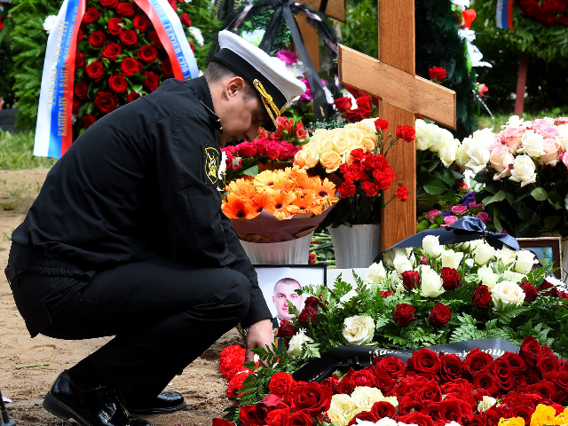 A navy officer mourns after a funeral ceremony at a cemetery in Saint Petersburg on July 6