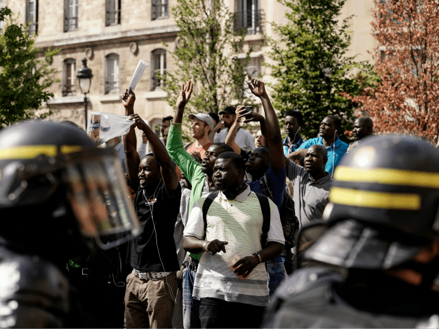 French police officers stand as undocumented migrants demonstrate to ask for the regularisation of their situation near the Pantheon in Paris, on July 12, 2019. (Photo by Kenzo TRIBOUILLARD / AFP) (Photo credit should read KENZO TRIBOUILLARD/AFP/Getty Images)