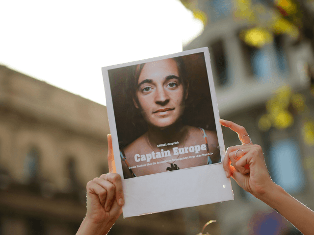 A protester holds a picture of migrant rescue ship Sea Watch captain Carola Rackete during a demonstration in Barcelona called by Spanish non-governmental organisation Proactiva Open Arms against the criminalisation of migrant rescue missions on July 13, 2019. - German national Rackete, 31, was arrested after defying a blockade imposed …