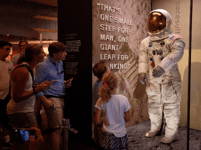 Visitors look at Neil Armstrong's Apollo 11 spacesuit after it was unveiled for the first
