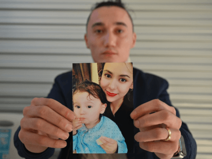 Sadam Abdusalam holds up a photo of his Uighur wife Nadila Wumaier and their baby son Luti