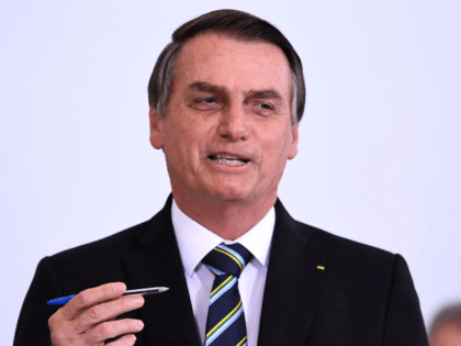 Brazilian President Jair Bolsonaro gestures during a ceremony to commemorate the first 200 days of his administration at Planalto Palace in Brasilia, on July 18, 2019. - Bolsonaro signed a membership application for the Organisation for Economic Co-operation and Development (OECD) during the ceremony. (Photo by EVARISTO SA / AFP) …