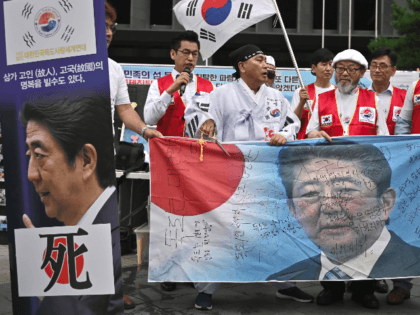 South Korean protestors hold a banner showing a picture of Japanese Prime Minister Shinzo Abe during a rally denouncing Japan for its recent trade restrictions against Seoul over wartime slavery disputes, near the Japanese embassy in Seoul on July 23, 2019. - After South Korea's high court ordered Japanese firms …