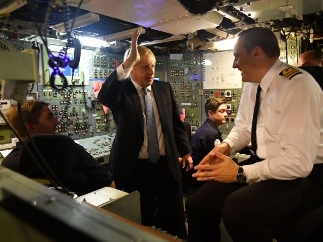 Commander Justin Codd (R) chats with Britain's Prime Minister Boris Johnson (2nd L) a