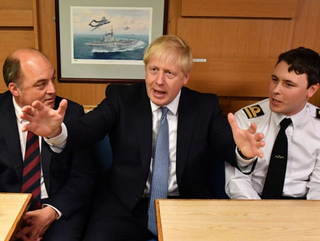 Britain's Prime Minister Boris Johnson (C) gestures as he chats with crew members of