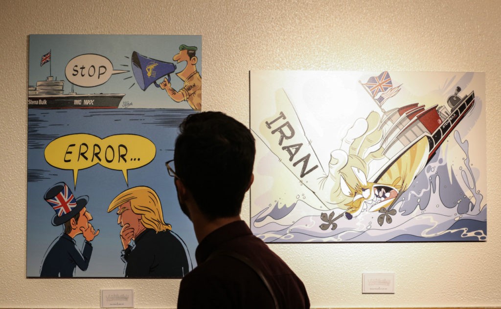 A man views caricatures at the "Pirates of the Queen" cartoon exhibition showing artwork by Iranian artists portraying Britain's Queen Elizabeth II as a "pirate" over the seizure of an Iranian oil tanker earlier in the month, at the Osveh Art and Cultural Center in the capital Tehran on July 30, 2019. - Historically strained ties between Tehran and London worsened when British Royal Marines took part in the seizure of Iran's "Grace 1" oil tanker off UK overseas territory Gibraltar on July 4. That was followed by the seizure by Iran's Islamic Revolutionary Guard Corps of a UK-flagged tanker in the Strait of Hormuz on July 19 -- in what Britain called a "tit-for-tat" move. Forty cartoons have gone on display to throw the spotlight on the British seizure, which saw supreme leader Ayatollah Ali Khamenei accuse the "vicious British" of "piracy". (Photo by ATTA KENARE / AFP) (Photo credit should read ATTA KENARE/AFP/Getty Images)