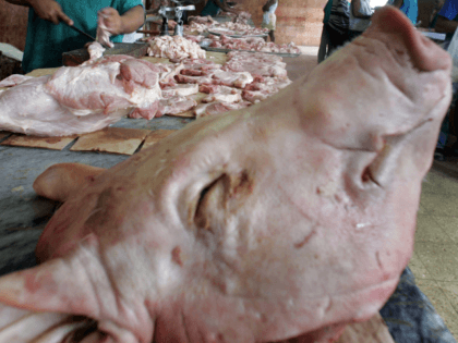 A butcher cuts pork into pieces 28 November 2006 in Havana, Cuba. The military parade Saturday at which Fidel Castro is widely expected -- though his attendance is not officially confirmed -- is the climax of almost a week of festivities. Some 300,000 people are expected to march, and 2,000 …