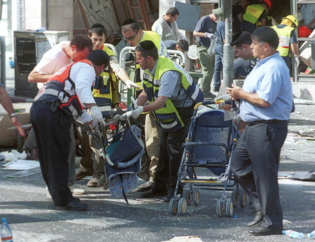 Israeli volunteers remove baby carriages from the scene of a Palestinian suicide bombing August 9, 2001 in Jerusalem, Israel. At least 18 people, including six children, were killed in the explosion, and more than 80 other people were injured in the blast at a Sbarro pizzeria. The bombing occurred at lunch time at the busy intersection of Jaffa and St. George''s streets in the heart of downtown Jerusalem. (Photo by Getty Images)