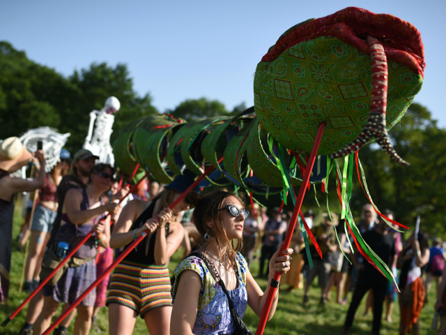 Protestors from Climate change group Extinction rebellion walk through Glastonbury Festival of Music and Performing Arts on Worthy Farm near the village of Pilton in Somerset, South West England, on June 27, 2019. (Photo by Oli SCARFF / AFP) (Photo credit should read OLI SCARFF/AFP/Getty Images)