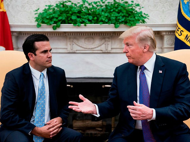 Governor of Puerto Rico Ricardo Rossello (L) listens while US President Donald Trump makes