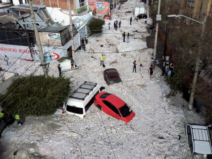 TOPSHOT - Vehicles buried in hail are seen in the streets in the eastern area of Guadalajara, Jalisco state, Mexico, on June 30, 2019. - The accumulation of hail in the streets of Guadalajara buried vehicles and damaged homes. (Photo by ULISES RUIZ / AFP) (Photo credit should read ULISES …