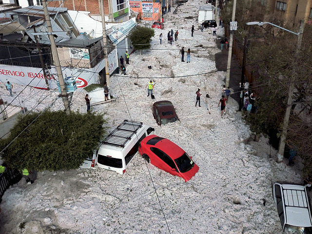 TOPSHOT - Vehicles buried in hail are seen in the streets in the eastern area of Guadalaja