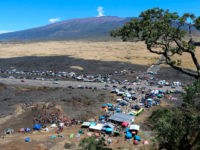 In this Sunday, July 21, 2019, photo provided by the Hawaii Department of Land and Natural Resources, protesters block a road to the summit of Mauna Kea in Hawaii. Scientists want to build the telescope atop Mauna Kea because it is one of the best sites in the world for …
