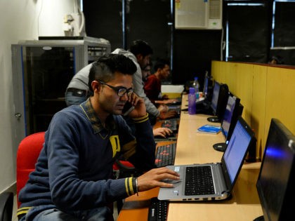 In this photograph taken on December 13, 2016, an employee of Indian IT security solutions company Innefu Labs works at their offices in New Delhi. In the darkened offices of a tech start-up, a handful of computer engineers sift through a mountain of intelligence data that would normally be the …