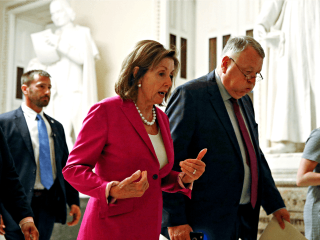 House Speaker Nancy Pelosi of Calif., left, walks out of the House Chamber, Tuesday, July