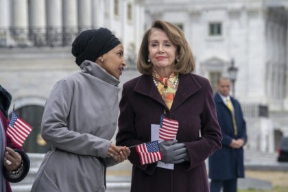 Rep. Ilhan Omar, D-Minn., left, whispers to Speaker of the House Nancy Pelosi, D-Calif., a