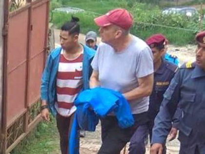 In this Monday, July 8, 2019 photo, Canadian aid worker Peter Dalglish, center wearing red cap, is brought to appear before the Kavre District Court in Nepal. Dalglish was Monday sentenced to nine years in prison in Nepal for sexually abusing two boys who were found at his home. (AP …