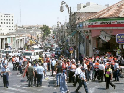 Israeli medics and volunteers treat the injured at the site of a Palestinian suicide bombing August 9, 2001 in Jerusalem, Israel. At least 18 people, including six children, were killed in the explosion, and more than 80 other people were injured in the blast at a Sbarro pizzeria. The bombing …