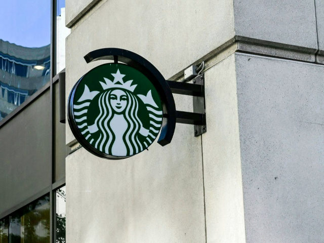 A Starbucks logo hangs over a store entrance in Washington, DC June 11, 2019. (Photo by EV