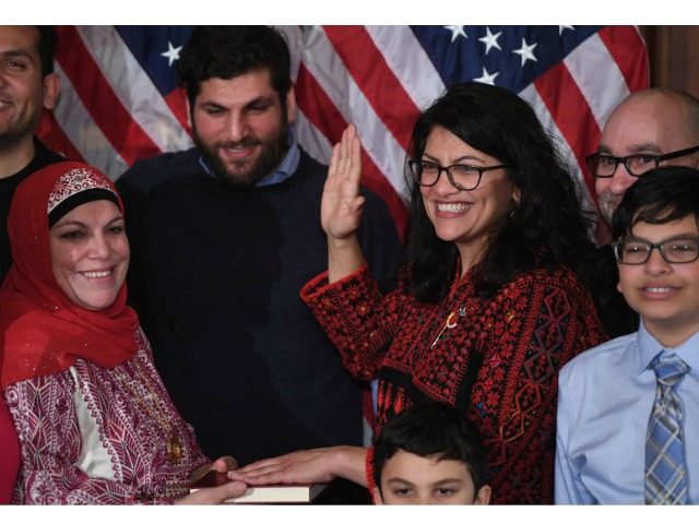Rep. Rashida Tlaib (center), wearing a traditional Palestinian robe, takes the oath of office on a Quran at the start of the 116th Congress at the U.S. Capitol on Thursday. Saul Loeb/AFP/Getty Images
