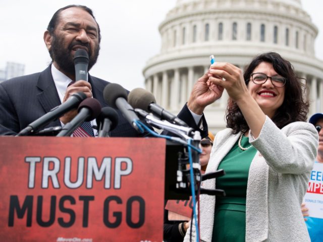 US Representative Rashida Tlaib (R), Democrat of Michigan, and US Representative Al Green, Democrat of Texas, hold a computer flash drive during a press conference at the US Capitol in Washington, DC, May 9, 2019. - The drive contains 10 million signatures on a petition urging the US Congress to …