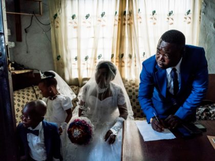 OPSHOT - Chinyere (Godgiven) and her husband-to-be Jones (R) prepare wedding documents during a service at the Evangelic Calvary Life Mission Church on May 28, 2017 in the Osusu district of Aba. / AFP PHOTO / MARCO LONGARI (Photo credit should read MARCO LONGARI/AFP/Getty Images)