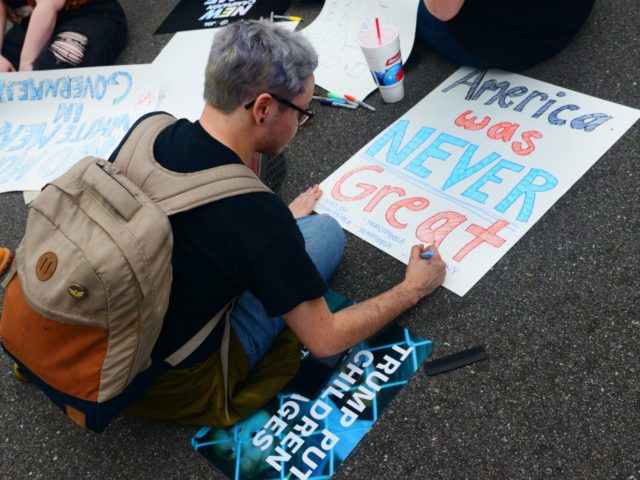 ORLANDO, FLORIDA - JUNE 18: An anti-Trump protester makes a sign during a protest against President Donald Trump outside a rally where Trump officially launched his re-election campaign on June 18, 2019 in Orlando, Florida. (Photo by Gerardo Mora/Getty Images)