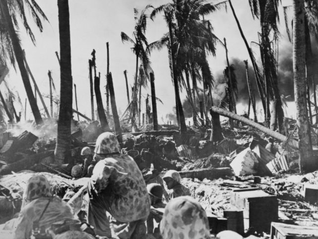 American Marines approach a group of Japanese-occupied buildings, which have been reduced