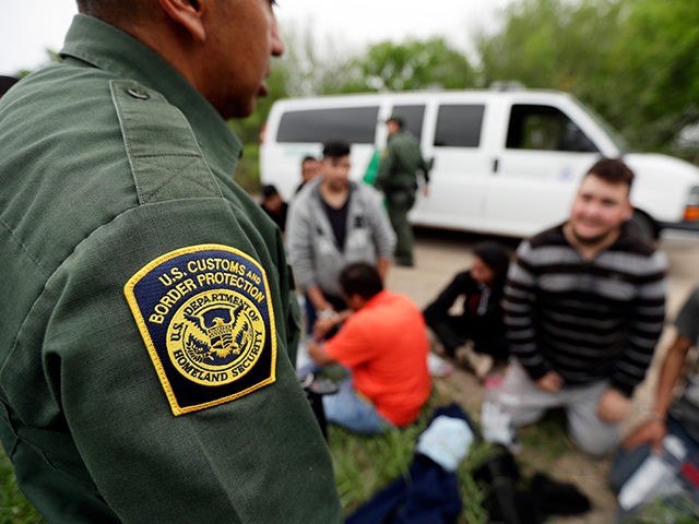 In this Thursday, March 14, 2019, photo, a Border Patrol agent talks with a group suspected of having entered the U.S. illegally near McAllen, Texas. While many adults crossing the border on their own in South Texas try to flee agents, most migrant parents and children wait to surrender so …