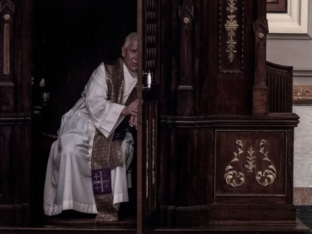 A priest hears a confession at the Metropolitan Cathedral in San Jose, Costa Rica on June
