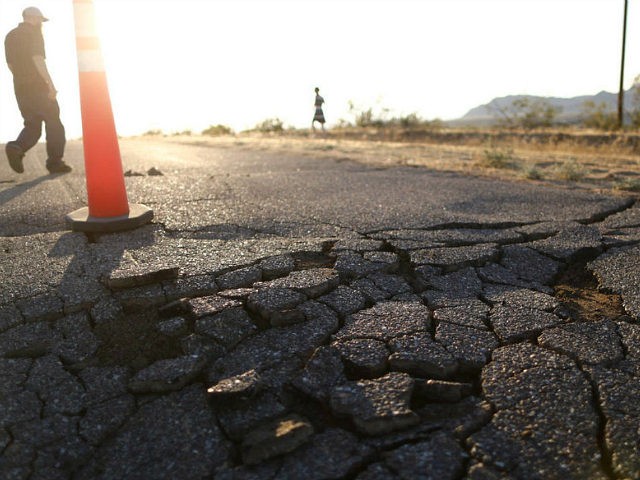 RIDGECREST, CALIFORNIA - JULY 04: People walk near cracks in the road after a 6.4 magnitude earthquake struck the area on July 4, 2019 near Ridgecrest, California. The earthquake was the largest to strike Southern California in 20 years with the epicenter located in a remote area of the Mojave …