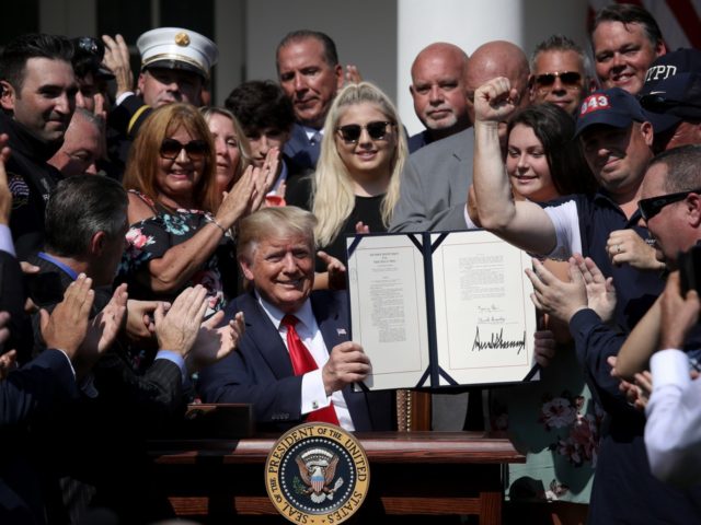 WASHINGTON, DC - JULY 29: As first responders and their families celebrate, U.S. President Donald Trump shows off his signature on H.R. 1327, an act to permanently authorize the September 11th victim compensation fund, in the Rose Garden of the White House July 29, 2019 in Washington, DC. The bill …