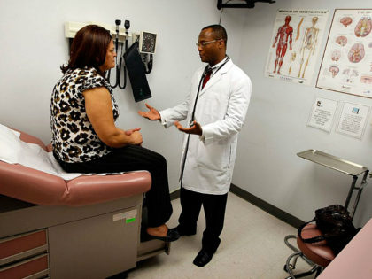 POMPANO BEACH, FL - APRIL 20: Emlyn Louis, MD speaks with Julia Herrera as he examines her at the Broward Community & Family Health Center on April 20, 2009 in Pompano Beach, Florida. Mr. Louis's job was saved when the American Recovery and Reinvestment Act provided funds for community health …