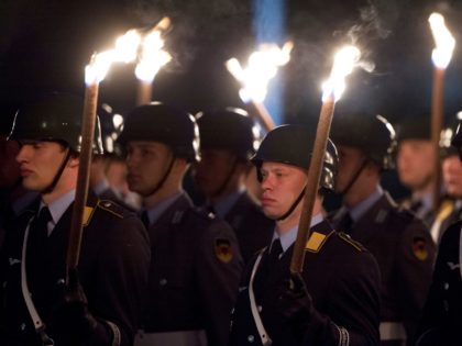 German soldiers stand to attention during a torchlit procession to bid farewell to NATO Supreme Allied Commander Europe (SACEUR) US Admiral James Stavridis at the defence ministry in Berlin April 17, 2013. AFP PHOTO / JOHN MACDOUGALL (Photo credit should read JOHN MACDOUGALL/AFP/Getty Images)