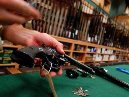 HAMBURG, PA - SEPTEMBER 17: Bob Colden places gun locks on guns for sale at Cabela's September 17, 2003 in Hamburg, Pennsylvania. Cabela's 250,000 square foot first retail outlet on the east coast features a 55,000 gallon walk through aquarium, a 30-foot-tall conservation mountain with game trophies in their own …