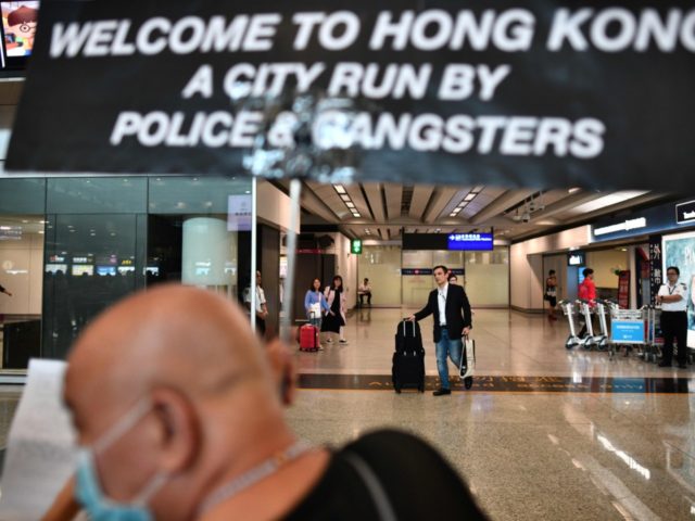 A protester (foreground) holds up a placard for recently landed passengers (back) to see a