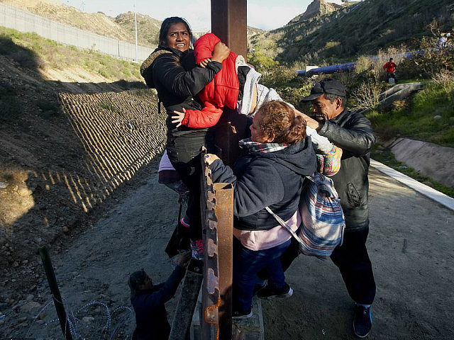 TIJUANA, MEXICO - JANUARY 06: Honduran migrants climb over the U.S.-Mexico border fence along on January 6, 2019 in Tijuana, Mexico. The U.S government is going into the third week of a partial shutdown with Republicans and Democrats at odds on agreeing with President Donald Trump's demands for more money …