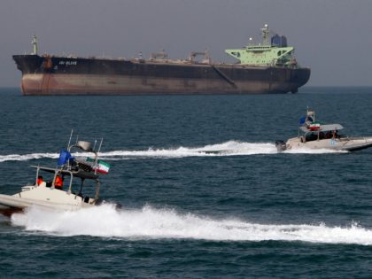 Iranian Revolutionary Guard speedboats cruise past an oil tanker off the port of Bandar Abbas, southern Iran, on July 2, 2012. Iran has come up with several methods to foil the European insurance embargo on ships loaded with its crude, a sanction which may harm its vital exports as much …