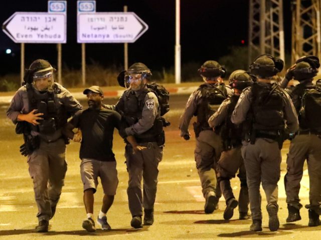 A member of the Ethiopian community of Israel is arrested by the police during clashes in