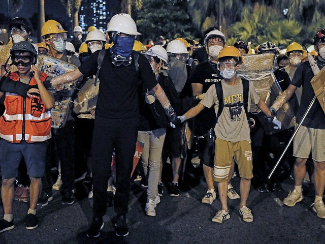 In this Sunday, July 14, 2019, photo, protesters wearing protection gears as they prepare